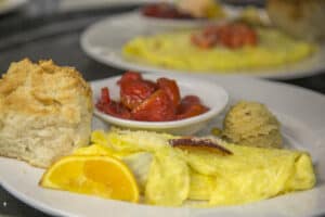 omelet, orange wedge, biscuit, sweet corn pone, and strawberries served at crockett's breakfast camp in gatlinburg