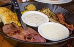 crockett's skillet with ham, biscuit, eggs, hash browns, bacon, grits, and gravy